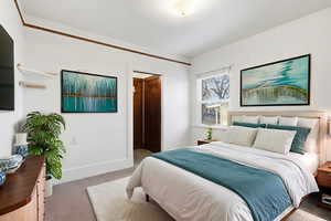 Bedroom with baseboards and light carpet