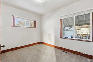 Carpeted spare room featuring wooden walls