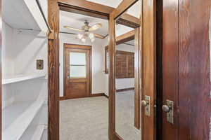 Hallway featuring light carpet and baseboards