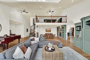 Living area with recessed lighting, a ceiling fan, ornamental molding, light wood finished floors, and vaulted ceiling