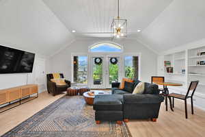 Living room with light wood-style flooring, recessed lighting, built in shelves, wooden ceiling, and vaulted ceiling