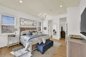 Bedroom with light wood-style floors, a chandelier, and ornamental molding