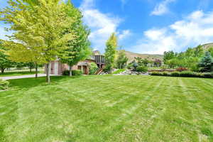 View of grassy yard featuring a mountain view and stairway