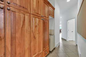 Corridor with light tile patterned floors and recessed lighting