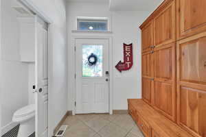Mudroom featuring light tile patterned floors and baseboards