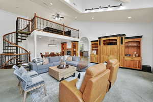 Living room featuring light carpet, arched walkways, recessed lighting, crown molding, and ceiling fan