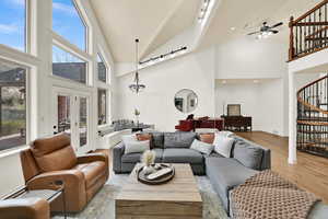 Living room featuring light wood finished floors, a ceiling fan, and vaulted ceiling