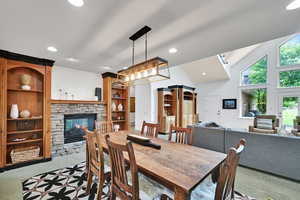 Dining area featuring a fireplace, carpet flooring, high vaulted ceiling, recessed lighting, and built in features