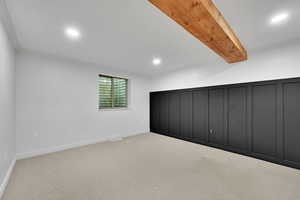 Unfurnished bedroom featuring light carpet, recessed lighting, and beamed ceiling