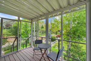 Sunroom featuring view of scattered trees