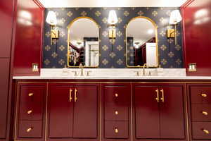 Bathroom featuring double vanity and wallpapered walls
