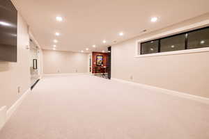 Recreation room with recessed lighting and light carpet