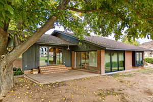 Rear view of house featuring a patio area and brick siding
