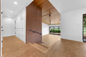 Hallway featuring wooden ceiling, wood finished floors, and lofted ceiling