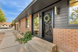 Doorway to property featuring brick siding and driveway