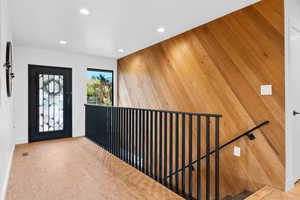 Foyer with wood walls and recessed lighting
