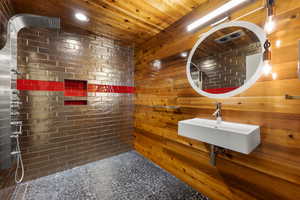 Full bath with wooden walls, tiled shower, and wood ceiling