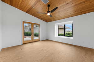 Unfurnished room featuring french doors, wooden ceiling, lofted ceiling, a ceiling fan, and light wood-type flooring