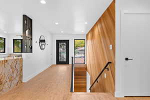 Entryway with wood walls and recessed lighting
