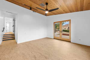 Unfurnished room featuring french doors, wooden ceiling, ceiling fan, stairway, and light wood-style flooring