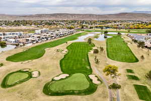 Aerial perspective of suburban area with a water and mountain view and a local golf course