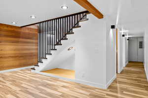 Stairway featuring wood walls, wood finished floors, and recessed lighting