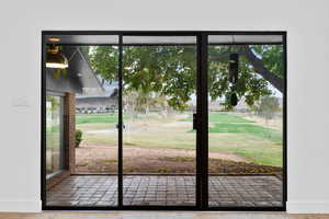 Doorway to outside featuring view of golf course and baseboards