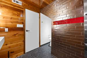 Bathroom featuring toilet and wooden ceiling