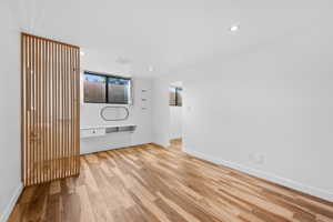 Empty room featuring light wood-style floors, built in study area, and recessed lighting