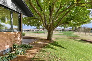 View of green lawn with a residential view and view of golf course