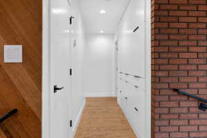 Hallway with light wood-style flooring and recessed lighting