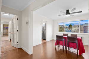 Dining area with ornamental molding, a mountain view, a ceiling fan, and wood finished floors