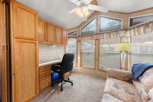Home office with light carpet, lofted ceiling, and a ceiling fan