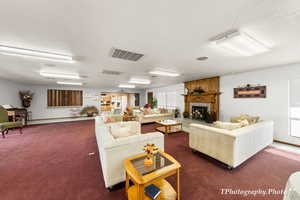 Living area featuring dark colored carpet, a textured ceiling, and a fireplace