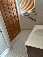 Bathroom with vanity, a stall shower, and tile patterned floors