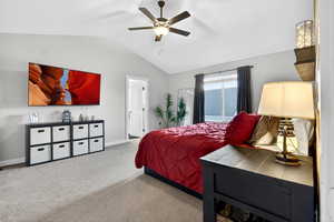 Bedroom with carpet flooring, vaulted ceiling, and ceiling fan
