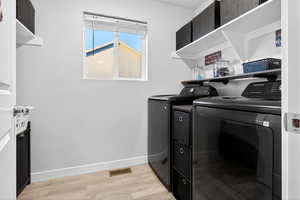 Laundry area with light wood finished floors and washing machine and dryer