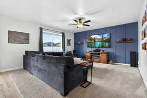 Living area featuring a decorative wall, ceiling fan, and an accent wall