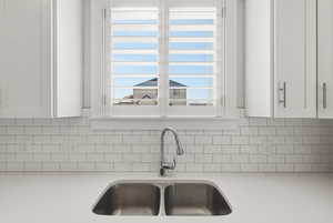 Kitchen view of white cabinets and light stone countertops
