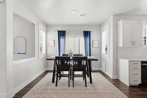 Dining area with dark wood finished floors and plenty of natural light