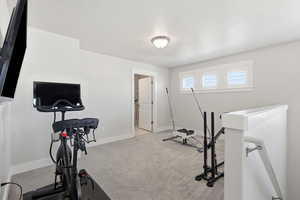 Workout room featuring light colored carpet and baseboards