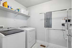 Washroom featuring independent washer and dryer and electric panel