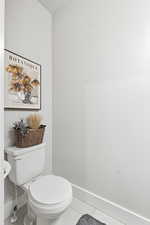 Half bath with baseboards and tile patterned floors