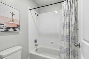 Full bath featuring shower / bath combo and toilet