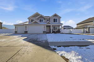View of front of house featuring stone siding, covered porch, concrete driveway, and a gate