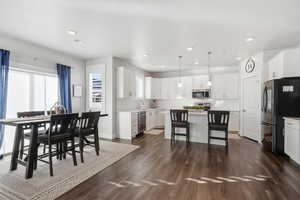 Dining room with dark wood-style flooring and recessed lighting