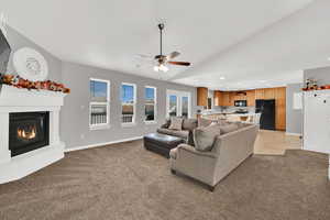 Living room with light colored carpet, recessed lighting, a glass covered fireplace, and ceiling fan