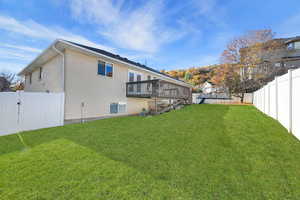 Rear view of property featuring a fenced backyard, a wooden deck, and stairway