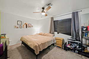 Bedroom featuring carpet flooring, a textured ceiling, and a ceiling fan