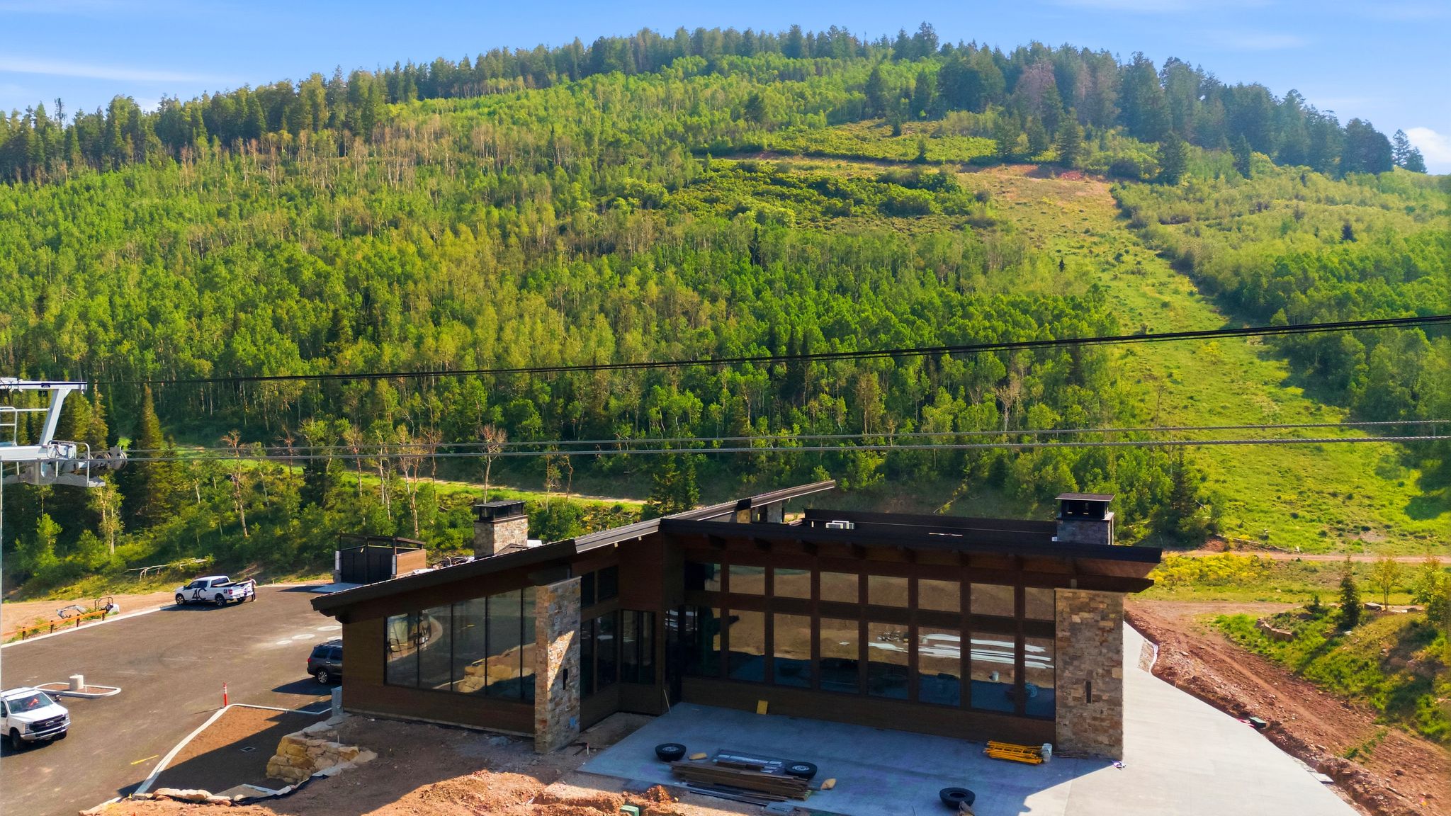 Contemporary architectural design featuring extensive window walls, stone accents, and a dark-toned roofline